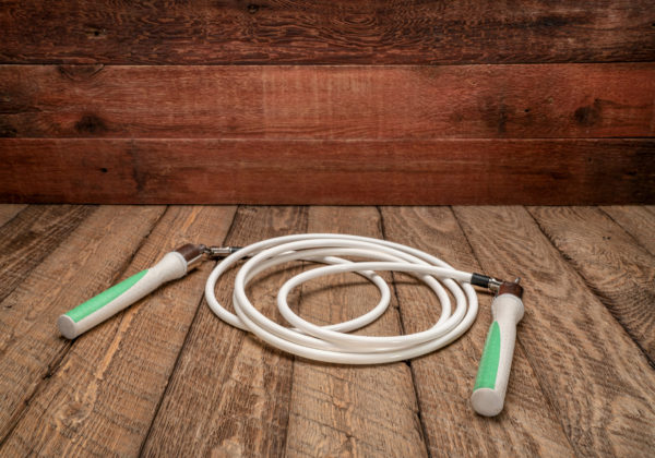 heavy fitness jump rope on rustic, weathered wood background