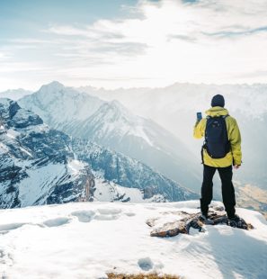 Climber take a mountain landscape photo on his smart phone. Hike