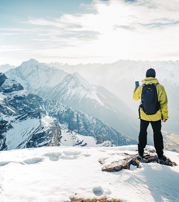 Climber take a mountain landscape photo on his smart phone. Hike